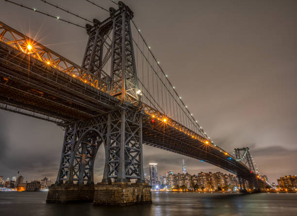 View of the Brooklyn, Manhattan and Williamsburg Bridge at night. Long Exposure Photo Shoot. The Williamsburg Bridge is a suspension bridge in New York City across the East River connecting the Lower East Side of Manhattan at Delancey Street with the Williamsburg neighborhood of Brooklyn williamsburg bridge photos stock pictures, royalty-free photos & images
