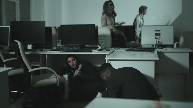 Businesspeople Hiding behind Desks during Zombie Apocalypse