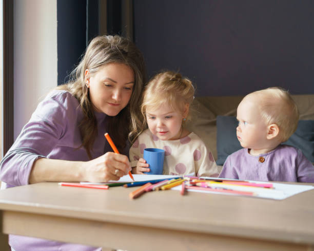 istock Caring young mom teaching how to draw her two little kids 1318689979