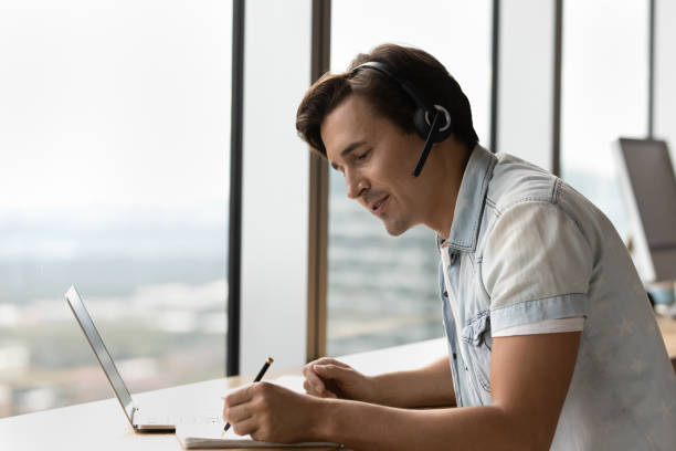 istock Young Caucasian man in headphones have webcam call 1318692295