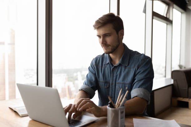 istock Pensive young man work on laptop online in office 1318692325