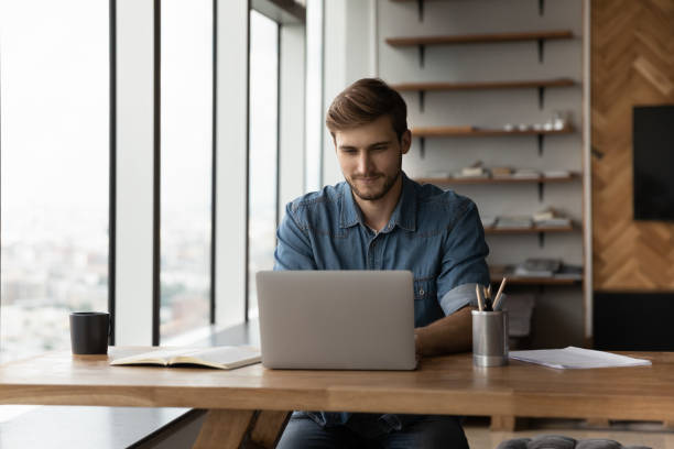 istock Young man work on laptop at home office 1318692347