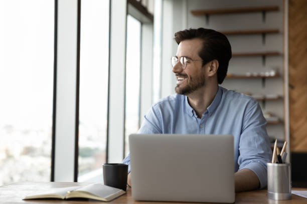 istock Happy businessman work on laptop looking in distance 1318692354