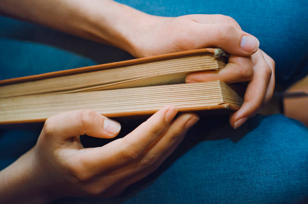 istock Close-up of hands holding a book. 1318692690