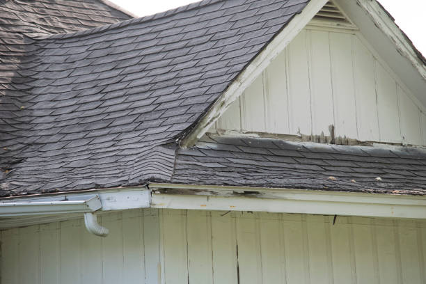 istock Damaged and old roofing shingles and gutter system on a house 1318693461