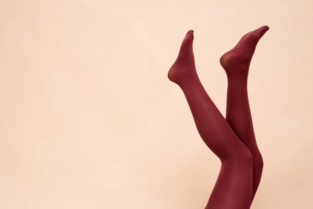 Legs. Woman raised up legs in the red stockings on the light background. tights stock pictures, royalty-free photos & images