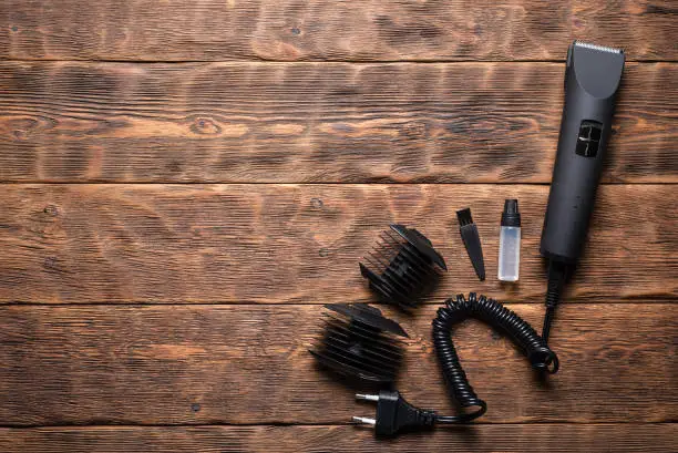 Hair clipper on the hairdresser work table flat lay background with copy space.