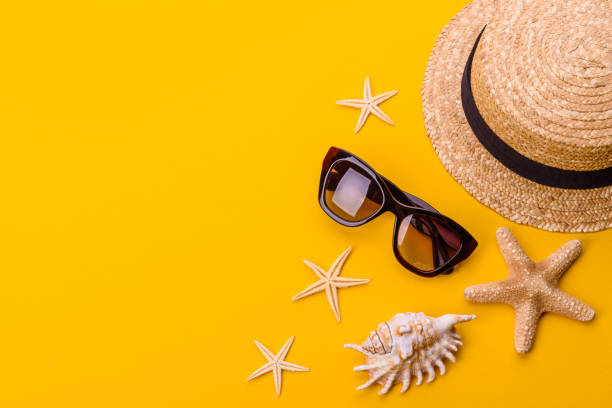 istock Beach accessories: glasses and hat with shells and sea stars on a colored background 1318697211