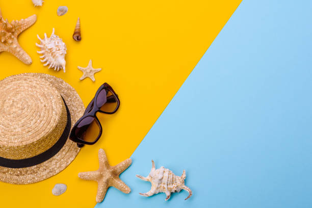 istock Beach accessories: glasses and hat with shells and sea stars on a colored background 1318697233