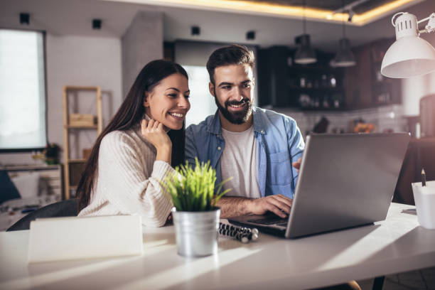 istock Cheerful loving young couple using laptop and analyzing their finances 1318697356
