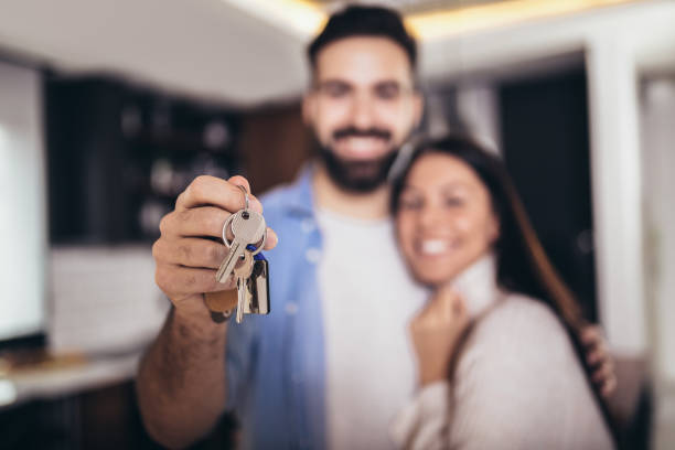 istock Couple showing keys to new home 1318698633