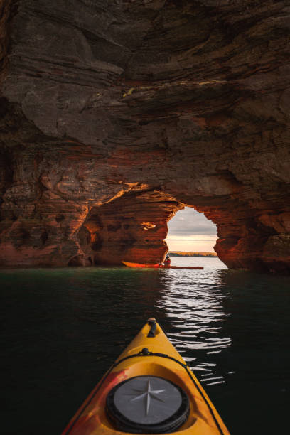 Apostle Island Sea Cave Kayakers This image from The Apostle Islands sea caves depicts two kayakers traversing the various tunnels carved by Lake Superior on the shores of Wisconsin bayfield county stock pictures, royalty-free photos & images