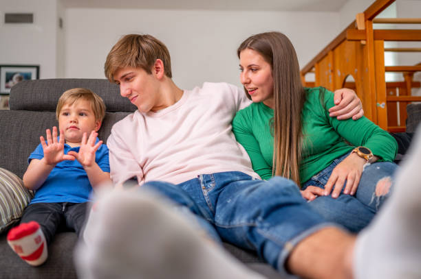 istock Young family sitting on a sofa and watching tv 1318704893