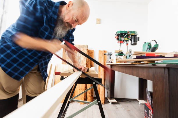 istock Woodworking, cutting wood plank using hand saw 1318711361