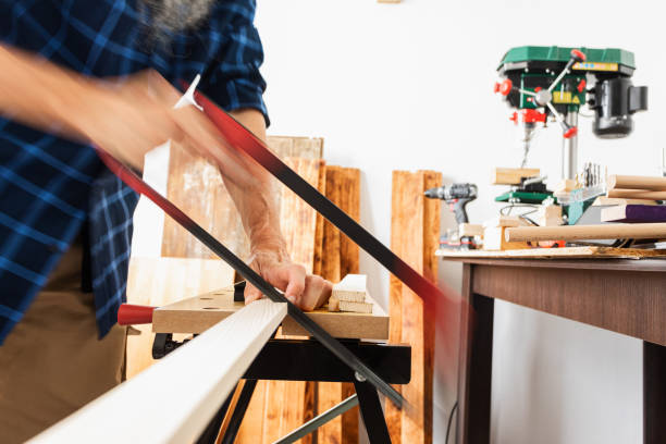 istock Woodworking, cutting wood plank using hand saw 1318711415