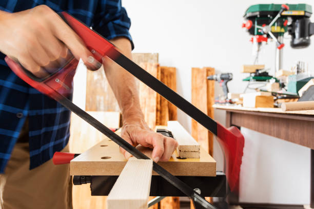 istock Woodworking, cutting wood plank using hand saw 1318711432