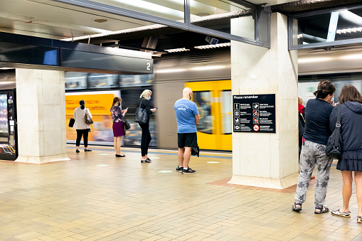Sydney, Australia - May 13, 2021: Train arriving in Martin Place subway train station with waiting passengers