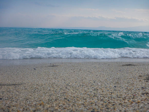 Seascape view with waves and sandy beach in windy day.