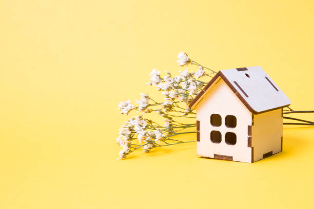 istock small wooden decorative and small white flowers on a background, yellow background, copy space 1318719497