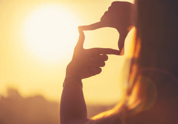 istock Fingers Framing the sun at sunset. 1318720311