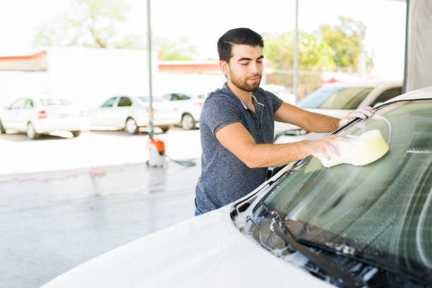 istock Happy guy enjoying washing his own car 1318721197