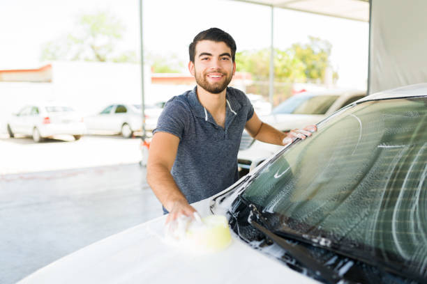 istock Cheerful man cleaning the car windows 1318721200