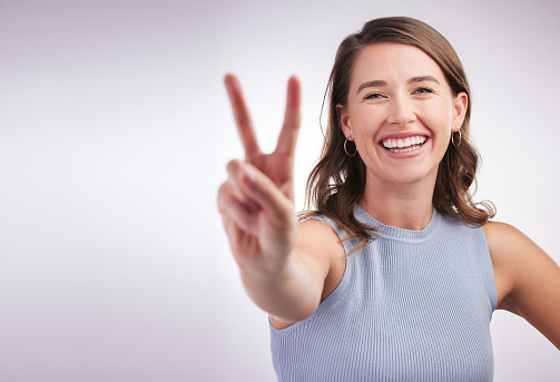 Portrait happy Asian woman shows ok sign and looking at the camera on yellow background.