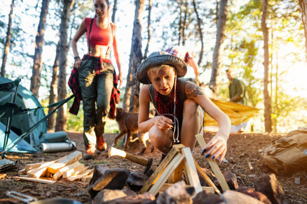 Young woman preparing wood for campfire