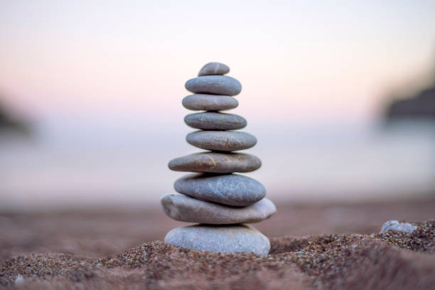 Balanced pebbles on beach sand stock photo