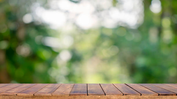 istock Natural wooden table background with blurred green natural background for displaying merchandise or designing important photo layouts. 1318739683