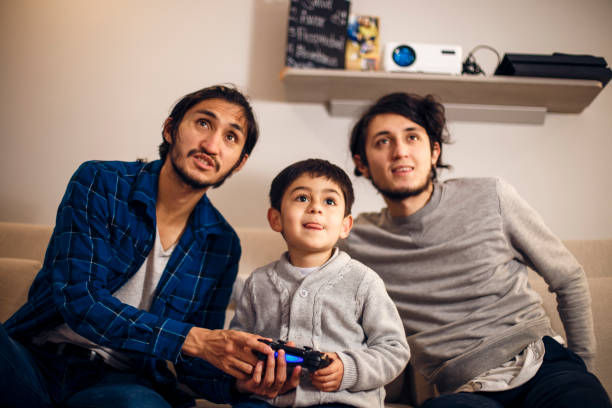 A little child playing games with his brothers at home stock photo