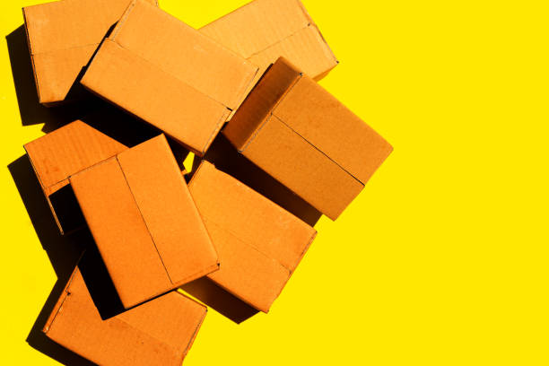 istock Brown cardboard boxes on yellow background. 1318741153