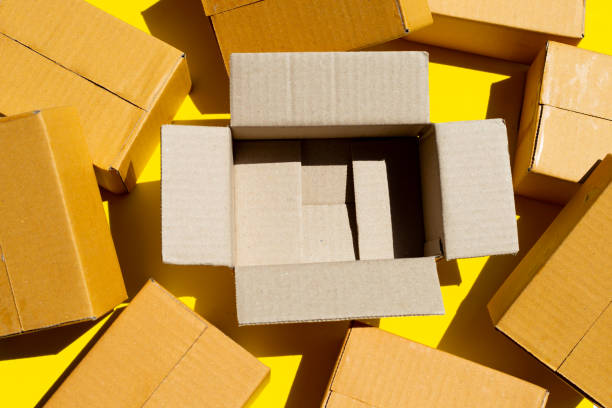 istock Brown cardboard boxes on yellow background. 1318742303