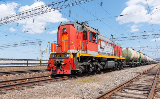 istock Freight locomotive pulls train with fuel tanks against blue sky. 1318748413