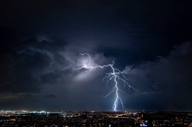 enorme fulmine sulle luci dei sobborghi della città di brisbane - storm cloud sky dramatic sky rain foto e immagini stock