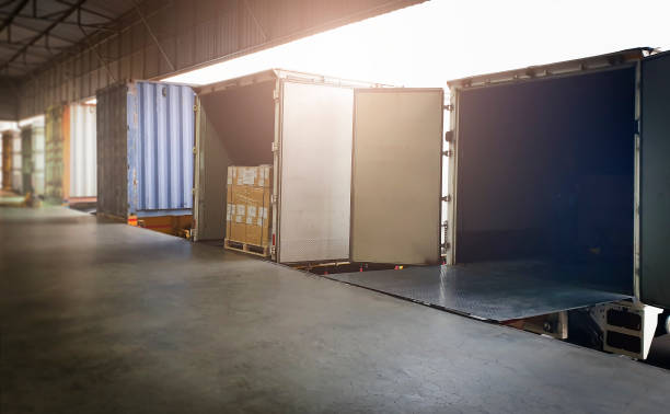 istock Trailer Trucks Parked Loading at Dock Warehouse. Shipping Warehouse Logistics.Cargo Shipment. Industry Freight Truck Transportation. 1318749494