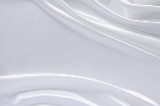 istock Elegant wavy and smooth white satin cloth texture background. 1318749502