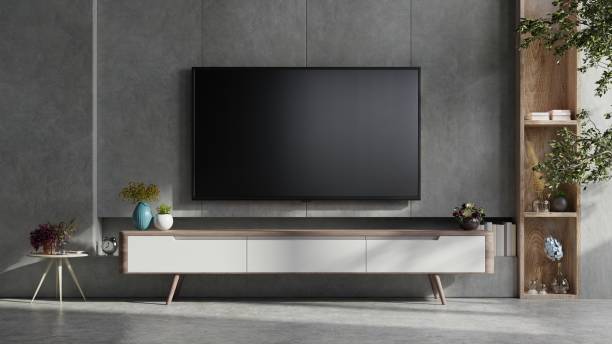 istock Mockup a TV wall mounted in a dark room with concrete wall. 1318750630