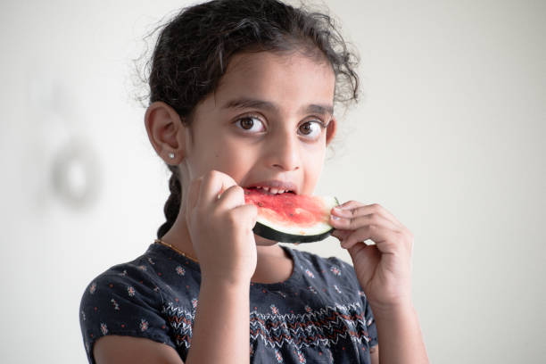 istock little girl eating watermelon 1318753400