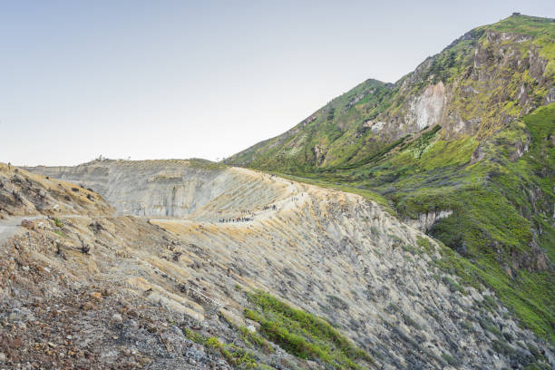 as magníficas vistas em montanhas verdes de uma estrada montanhosa que se desentuma até o vulcão ijen ou kawah ijen na língua indonésia. famoso vulcão contendo o maior do mundo lago ácido e ponto de mineração de enxofre no local onde gases vulcân - 5412 - fotografias e filmes do acervo