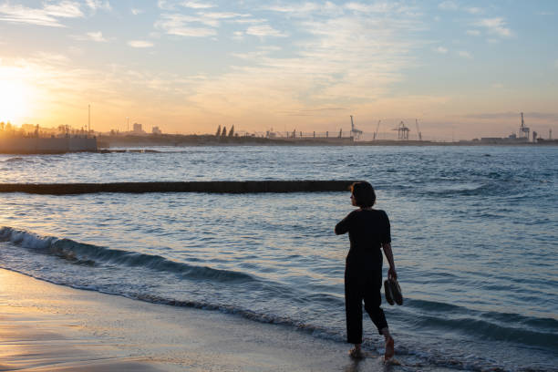 istock Woman seen walking at the beach during dusk 1318764599