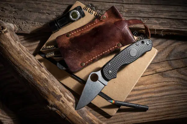 Photo of Pocket knife and hand torch. Everyday wear. Men's accessories for every day. Knife and keys.