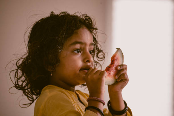 istock little girl eating watermelon 1318771433