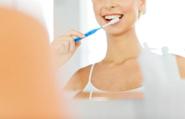 istock woman with toothbrush cleaning teeth at bathroom 1318775442