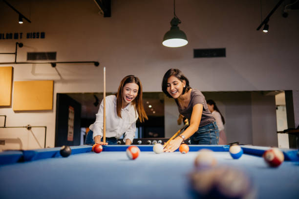 giovane donna impiegati gioca a biliardo in ufficio - pool game foto e immagini stock