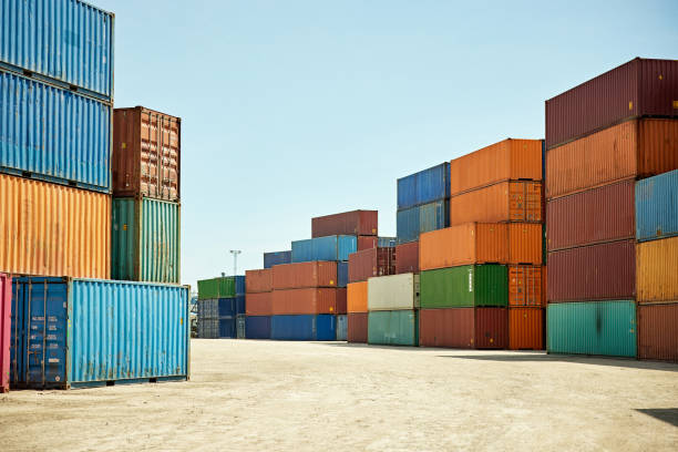 Stacked Intermodal Containers at Inland Port Multi-colored shipping containers stacked outdoors and awaiting transport from terminal to next destination. cargo container stock pictures, royalty-free photos & images