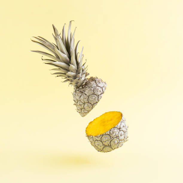istock Gray cut pineapple levitates above yellow background. Minimal style. Creative summer or food concept. 1318776782