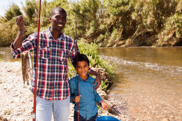 istock Man and boy with bucket of catch 1318776988