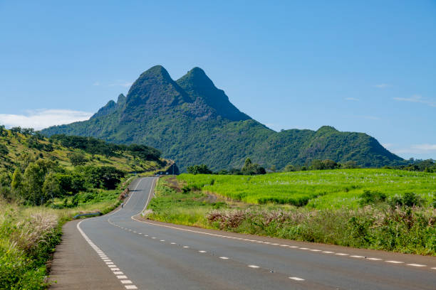 istock Road with mountains blue sky in the background 1318777785