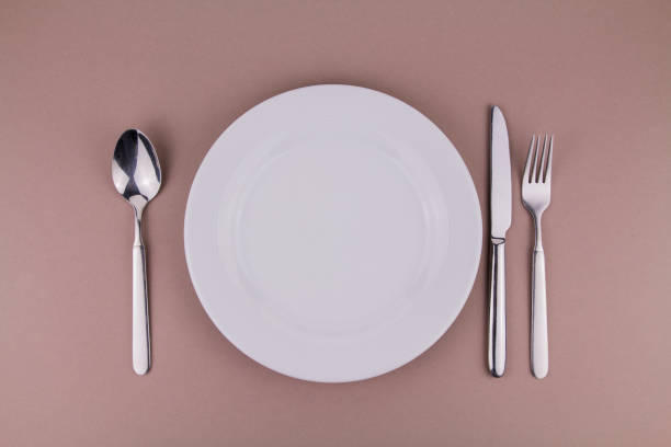 istock table setting plate fork spoon and knife on gray background white plate 1318781734